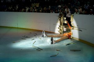 image d'une patineuse allongé entre la glace et la rambarde